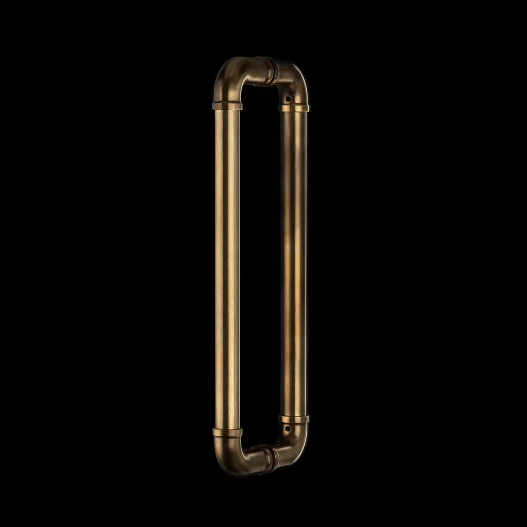 Clerke Door Pull (DP1064) Back-to-back glass in Mid Antique Brass Waxed - MABW on a black background.