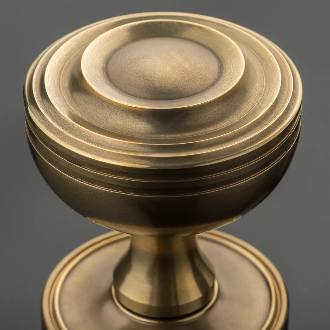 Arty Shot of Benedetto Door Knob (DK1076) (SP13043) in Mid Antique Brass Waxed - MABW on a black background