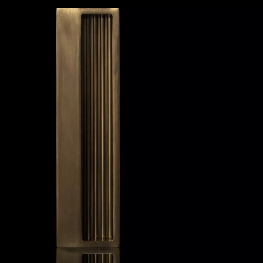 Arty Shot of Bespoke Recessed Pull with Ribbed Inlay (SP13308) in Mid Antique Brass Waxed - MABW on a black background