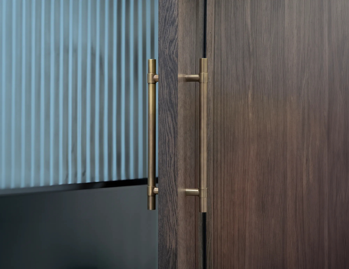 Workshop door with living vs. ageless finishes: left-hand Mid Antique Brass Waxed - MABW, right-hand Mid Antique Brass Ceramic - CMAB