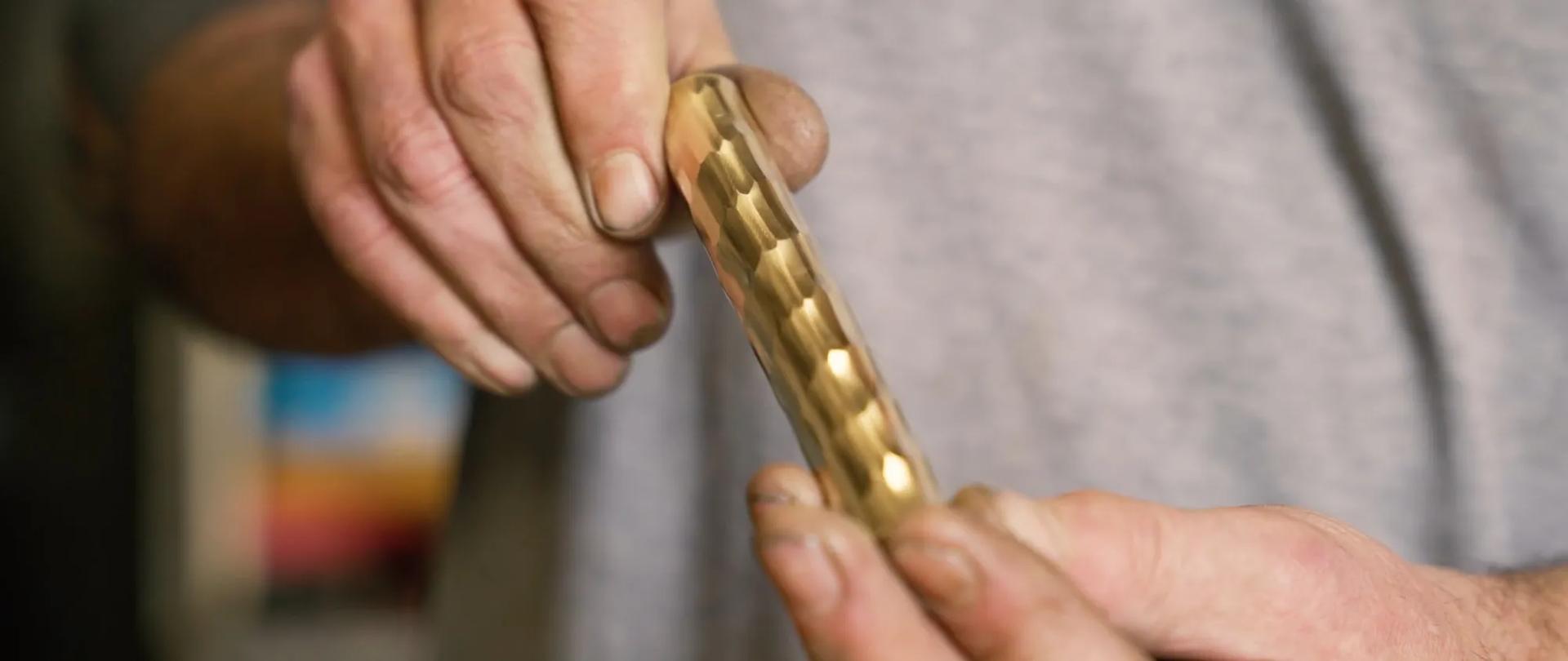 Blacksmith holding length of rolled & hammered texture