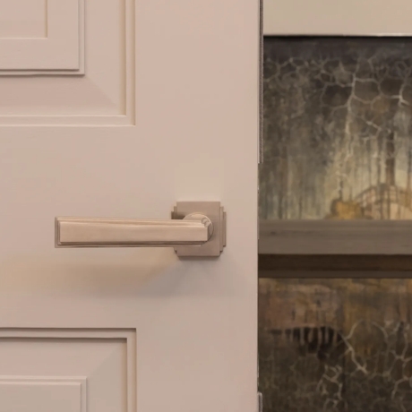 Dewhurst I Lever (LV1050) in Brushed Nickel on light door with out-of-focus background