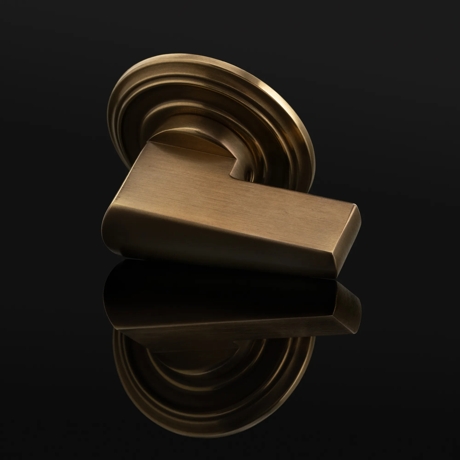 Arty shot of Wedge Thumb Turn (TT1130) in Mid Antique Brass Waxed - MABW on a black background